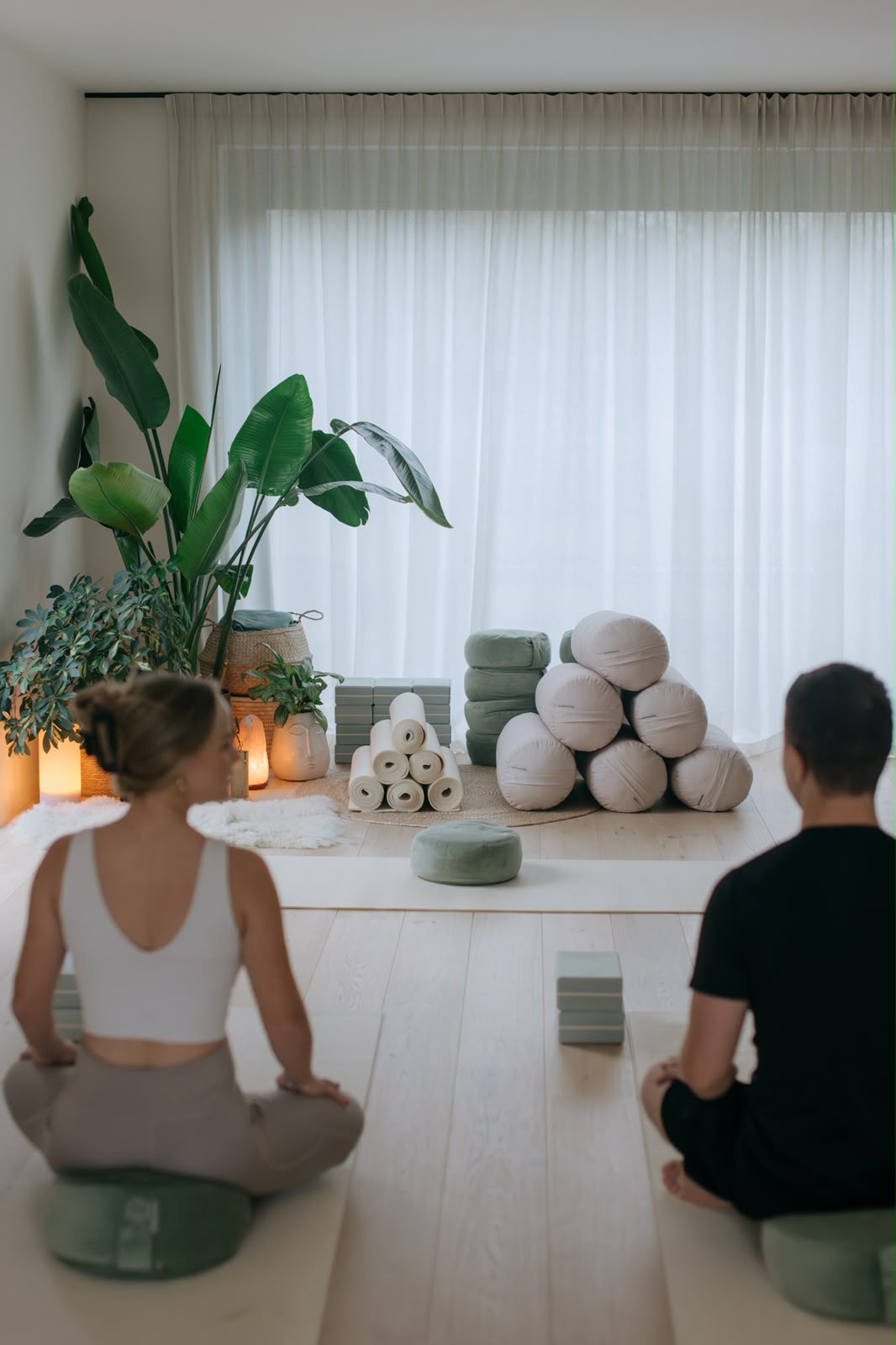 Twee deelnemers in meditatiehouding in de yogaruimte